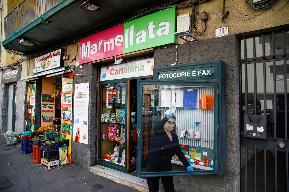 A vendor wearing a face mask cleans a display window in front of the store as the Italian government allows the reopening of some shops while a nationwide lockdown continues in Catania, Italy April 14, 2020. u00e2u20acu201d Reuters pic