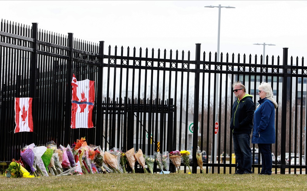 Two individuals observe the flowers of a memorial at the Royal Canadian Mounted Police (RCMP) Headquarters, in Dartmouth, Nova Scotia, Canada April 20, 2020. u00e2u20acu201d Reuters pic