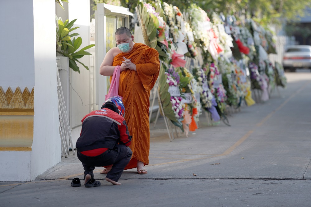 A monk wearing a face mask receives alms at a temple, during the coronavirus disease outbreak, in Bangkok April 21, 2020. u00e2u20acu201d Reuters pic