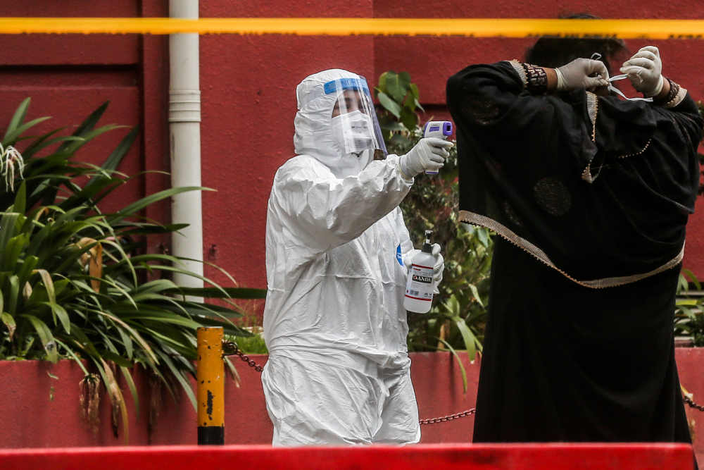 Health workers check the temperature of a Menara City One resident during enhanced movement control order (EMCO) in Kuala Lumpur April 5, 2020. u00e2u20acu201d Picture by Firdaus Latif