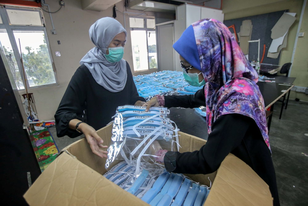 People work on a collaborative project between FSSR UiTM Perak, FSSR Shah Alam, UiTM Sg Buluh, Red Crescent Perak to produce personal protective equipment (PPE) at UiTM Seri Iskandar Art and Fashion workshop April 9, 2020. u00e2u20acu201d Picture by Farhan Najib