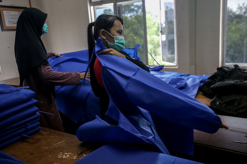 People work on a collaborative project between FSSR UiTM Perak, FSSR Shah Alam, UiTM Sg Buluh, Red Crescent Perak to produce personal protective equipment (PPE) at UiTM Seri Iskandar Art and Fashion workshop April 9, 2020. u00e2u20acu201d Picture by Farhan Najib