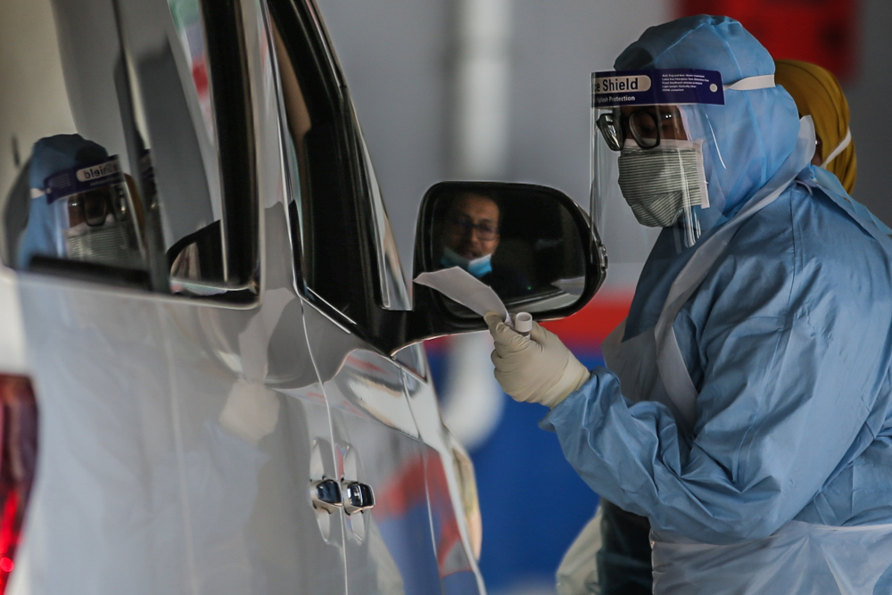 A medical worker takes a swab at a Covid-19 drive-through screening area at KPJ Ampang Puteri April 9, 2020. u00e2u20acu201d Picture by Hari Anggara