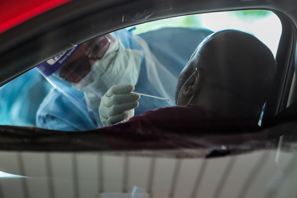 A medical worker takes a swab at a Covid-19 drive-through screening area at KPJ Ampang Puteri April 9, 2020. u00e2u20acu201d Picture by Hari Anggara