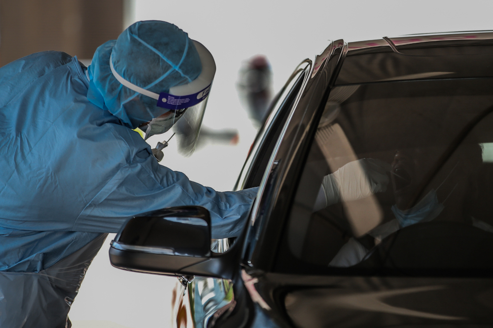 A medical worker takes a swab at a Covid-19 drive-through screening area at KPJ Ampang Puteri April 9, 2020. u00e2u20acu201d Picture by Hari Anggara