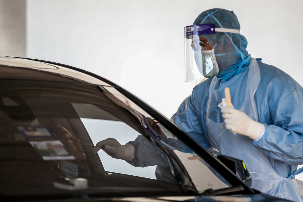 A medical worker takes a swab at a Covid-19 drive-through screening area at KPJ Ampang Puteri April 9, 2020. u00e2u20acu201d Picture by Hari Anggara