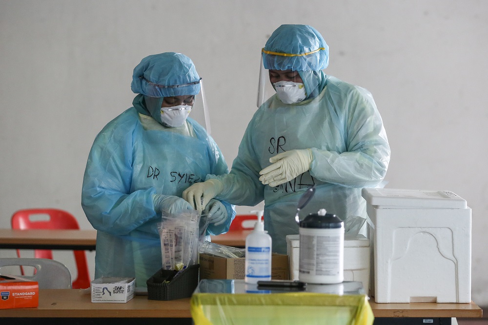 Health workers in protective suits are seen at a drive-through testing site for Covid-19 at MSU Medical Centre in Shah Alam April 10, 2020. u00e2u20acu201d  Picture by Yusof Mat Isa