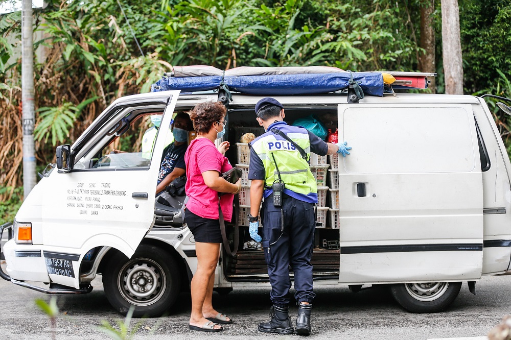 A policeman inspects a vehicle at a roadblock along Jalan Tun Sardon in Penang April 10, 2020. u00e2u20acu201d Picture by Sayuti Zainudin