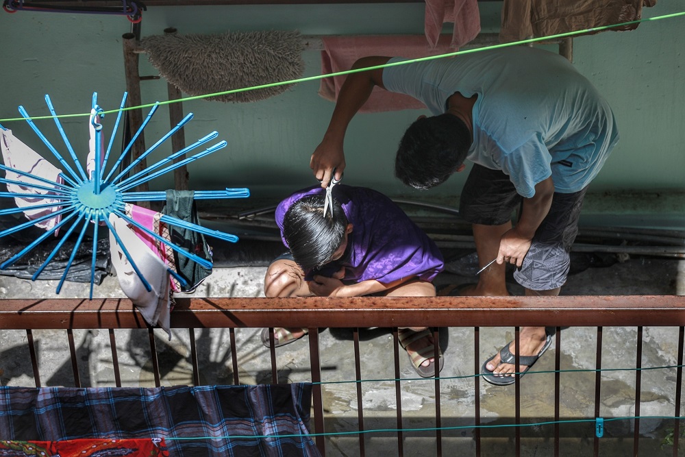 A man helps trim his friendu00e2u20acu2122s hair at their home during the movement control order in Kota Damansara April 12, 2020. u00e2u20acu201d Picture by Ahmad Zamzahuri