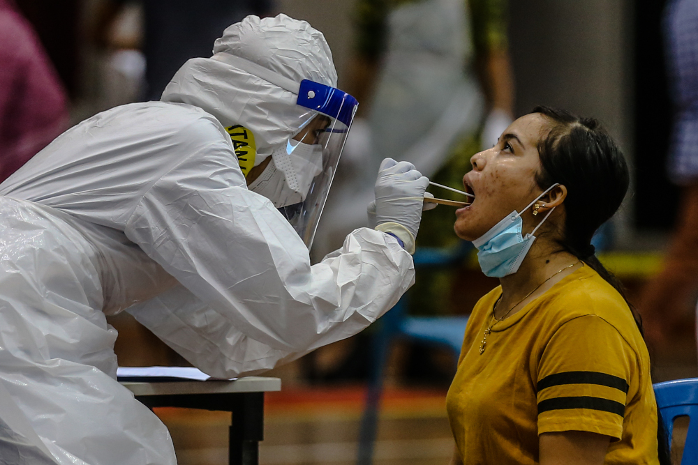 Health workers in protective suits are seen conducting Covid-19 testing in Kuala Lumpur April 12, 2020. u00e2u20acu201d Picture by Firdaus Latif 