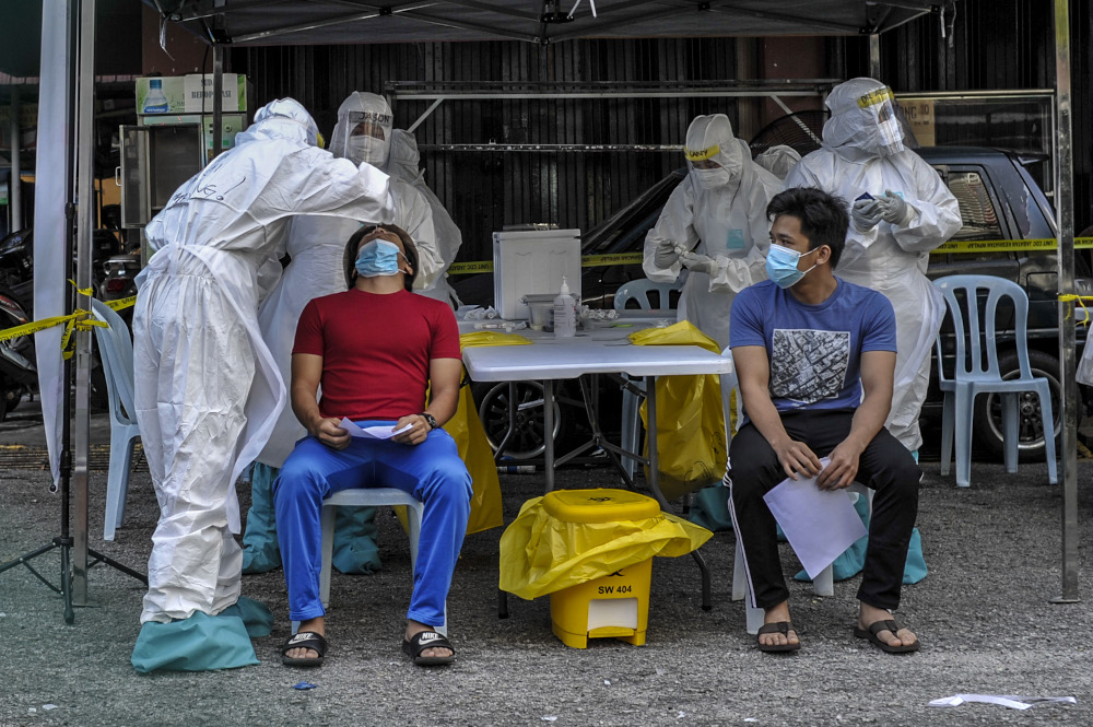 Health workers test members of the public for Covid-19 are pictured at the PKNS Kampung Baharu flat in Kuala Lumpur April 12, 2020. u00e2u20acu201d Picture by Shafwan Zaidon