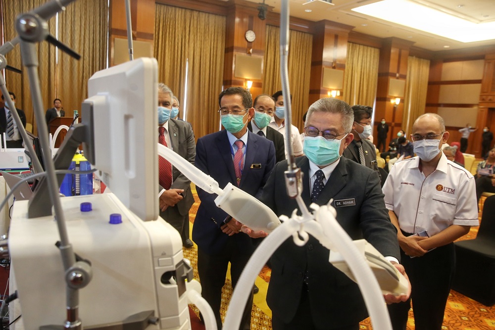 Health Minister Datuk Sri Dr Adham Baba (second right) inspects a prototype splitter kit during a media briefing at the Health Ministry in Putrajaya April 13, 2020. 