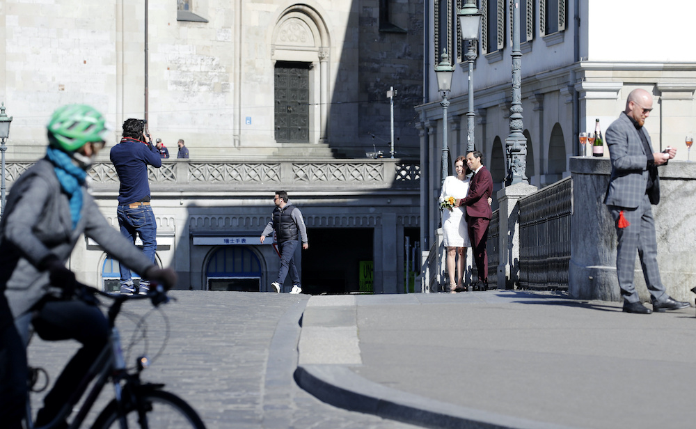 A couple poses after their wedding ceremony amid the coronavirus disease (Covid-19) outbreak, on the Muensterbruecke bridge in Zurich, Switzerland April 14, 2020.  u00e2u20acu201d Reuters pic