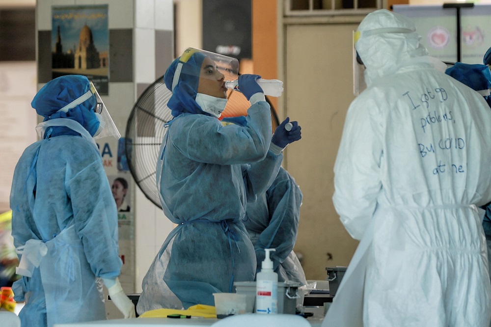 Health workers take a break at a Covid-19 testing site in Kampung Baru, Kuala Lumpur April 17, 2020. — Picture by Ahmad Zamzahuri
