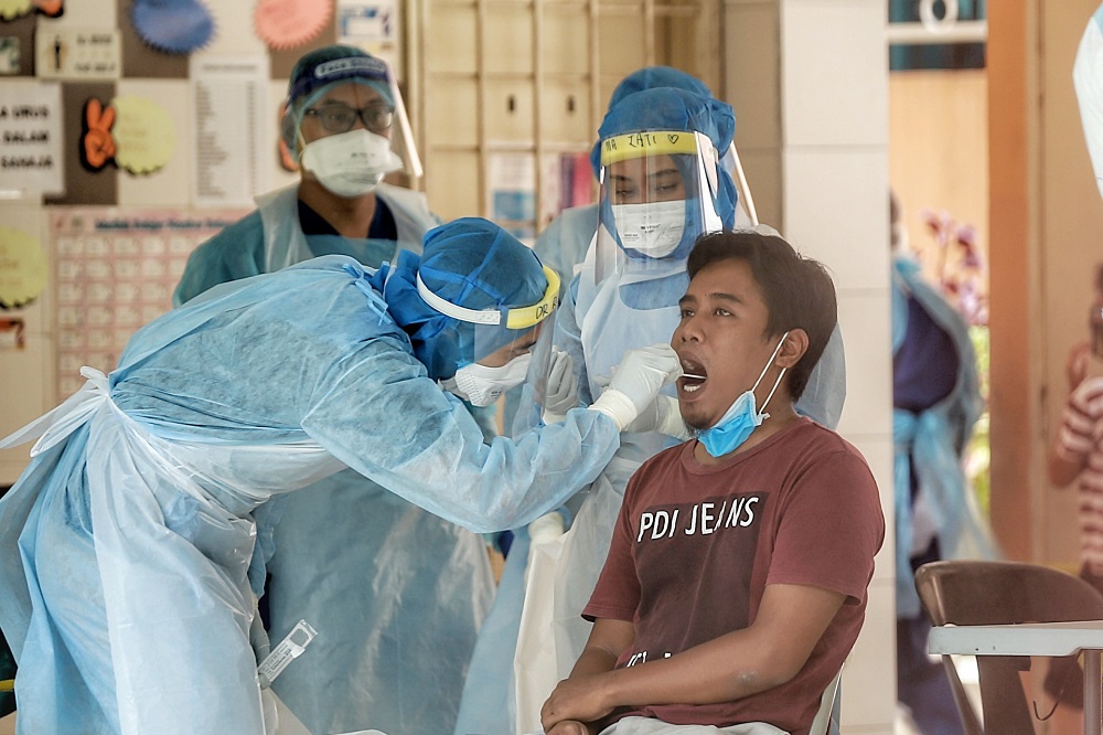 Health workers test a Kampung Baru resident for Covid-19 in Kuala Lumpur April 17, 2020. u00e2u20acu201d Picture by Ahmad Zamzahuri
