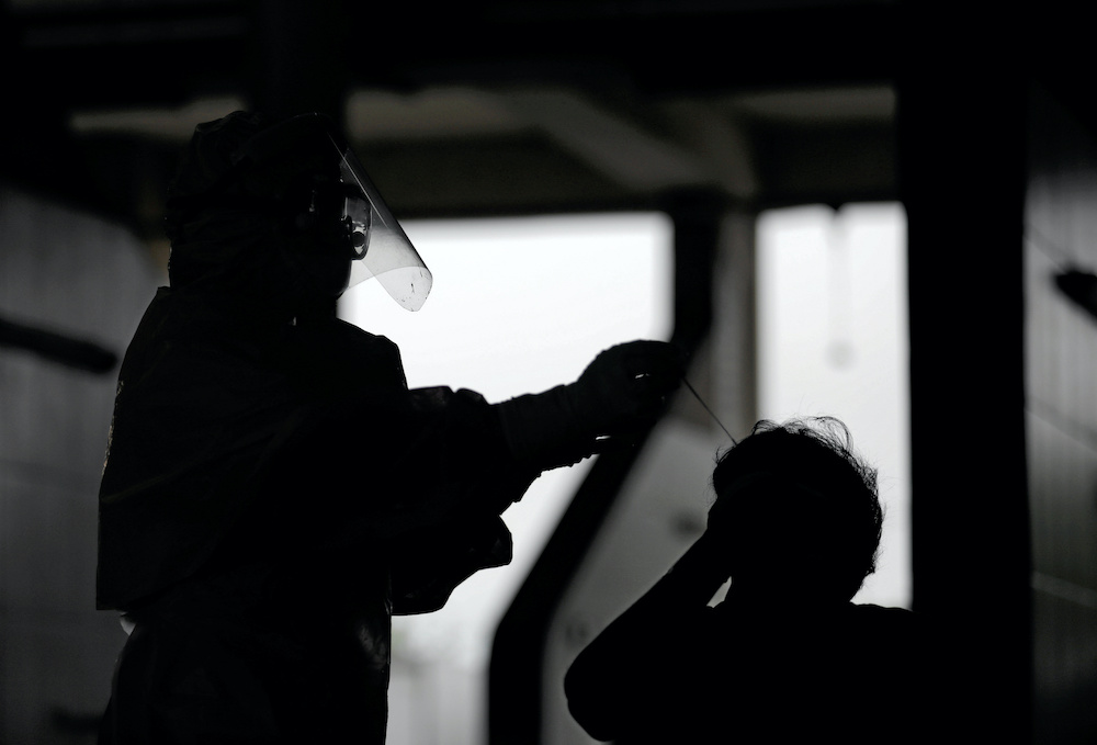 A man reacts as a health official uses a swab to collect a sample at a fish market during the curfew amid concerns about the spread of the coronavirus disease (Covid-19), in Colombo April 22, 2020. u00e2u20acu201d Reuters picn n