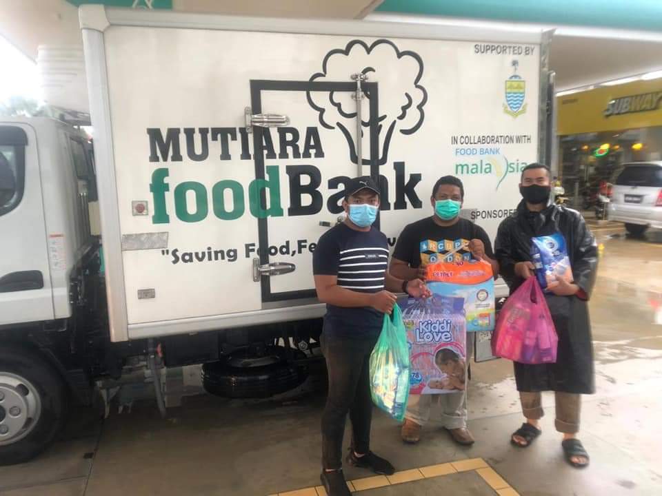 A representative of Penang Mutiara Food Bank handing over essential goods to 'Abang Tudung' (Right). — Photo courtesy of 'Abang Tudung'