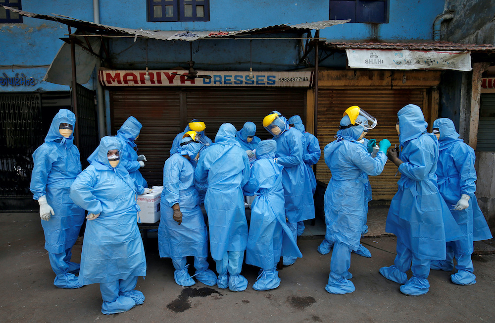 Doctors wearing protective gear gather to take swabs from the residents to test for coronavirus disease (Covid-19) at a residential area in Ahmedabad, India, April 8, 2020. u00e2u20acu201d Reutersnnnn