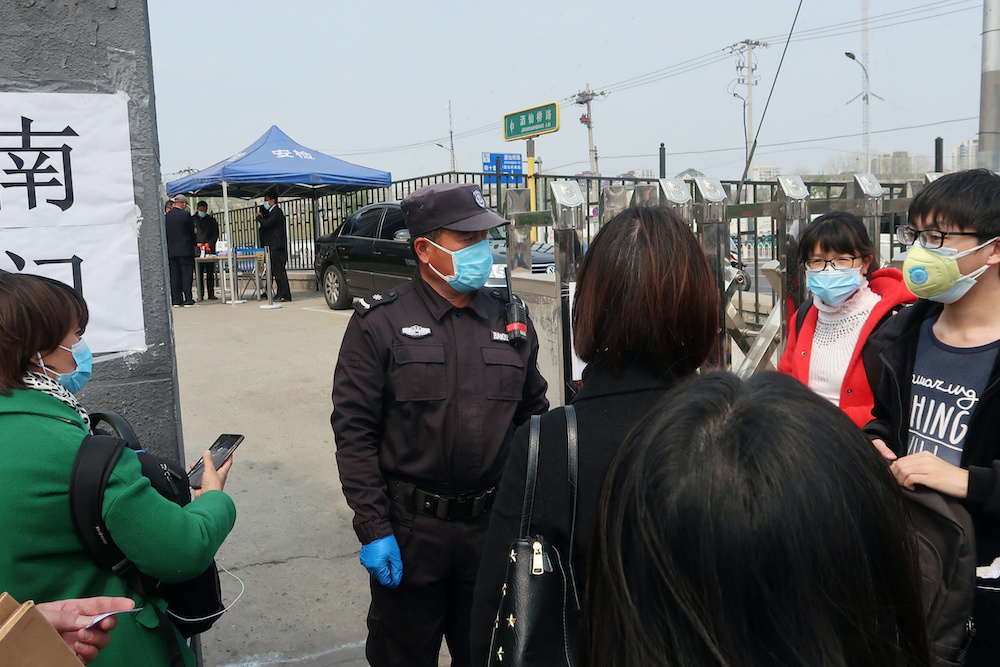 People wearing face masks to prevent the spread of the novel coronavirus disease (Covid-19) wait at an entrance to a labour arbitration office in Beijing, China April 9, 2020. u00e2u20acu2022 Reuters picnn