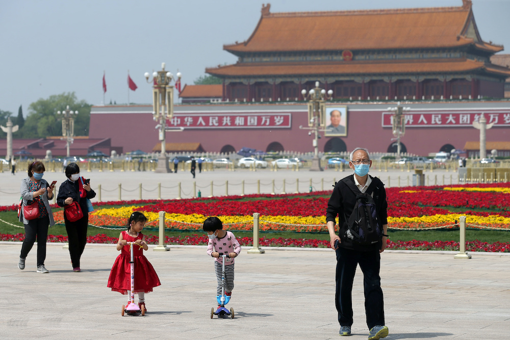 People wearing face masks following the coronavirus disease outbreak walk past flower installations set up to mark the upcoming Labour Day holiday, at Tiananmen Square in Beijing, China April 29, 2020. u00e2u20acu201d Reuters picnnn
