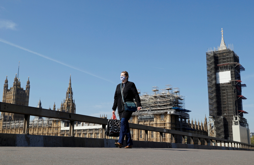 A woman wearing a face mask walks across Westminster Bridge with Big Ben clock and the Houses of Parliament in the background, as the spread of Covid-19 continues, in London, Britain, April 23, 2020. u00e2u20acu201d Reuters pic 