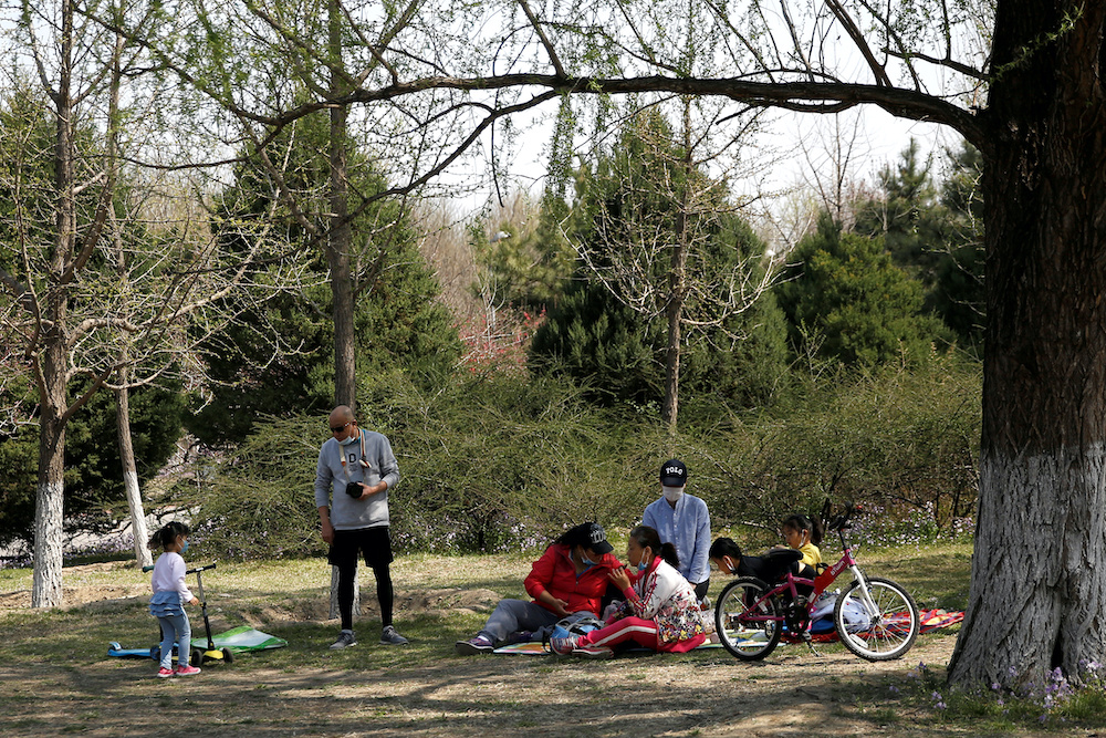 People wearing face masks enjoy a picnic at a park during Chinese Qingming festival holiday in Beijing, amid an outbreak of the novel coronavirus disease (Covid-19) in the country, China April 6, 2020. u00e2u20acu201d Reuters picnnn