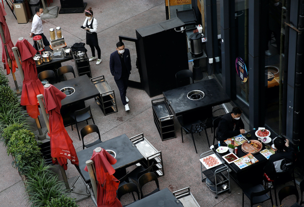 Customers wearing face masks are served at an outdoor seating of a hotpot restaurant in Beijing, as the spread of the novel coronavirus disease (Covid-19) continues in the country, China April 7, 2020. Picture taken April 7, 2020. — Reuters pic