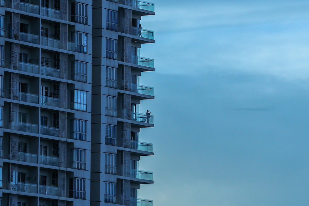 A woman is seen at the balcony of her apartment in Kuala Lumpur as people continue to adhere to the MCO, April 4, 2020. u00e2u20acu201d Picture by Firdaus Latif