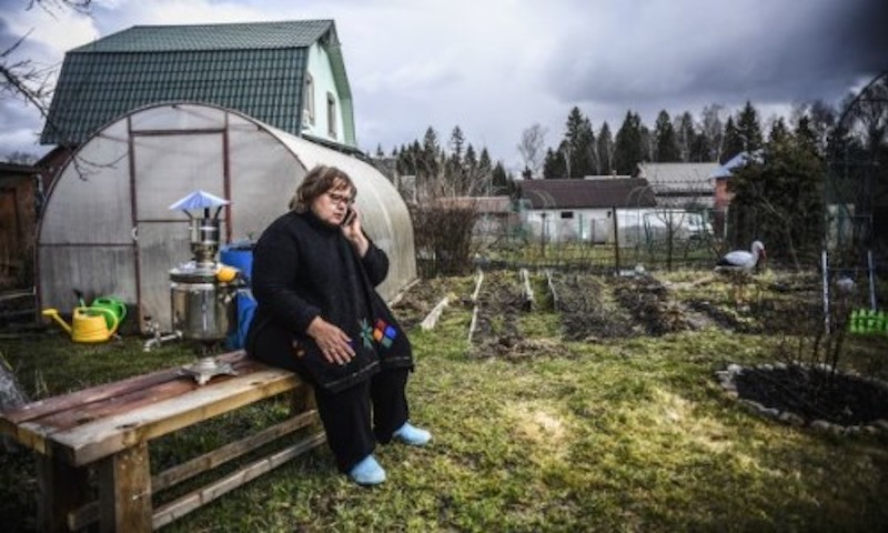 Nataliya Sapiga, a 53-year-old school teacher, talks on the phone in a yard of her countryside house in Sokolniki, west of Moscow. u00e2u20acu2022 AFP-Relaxnews picnn