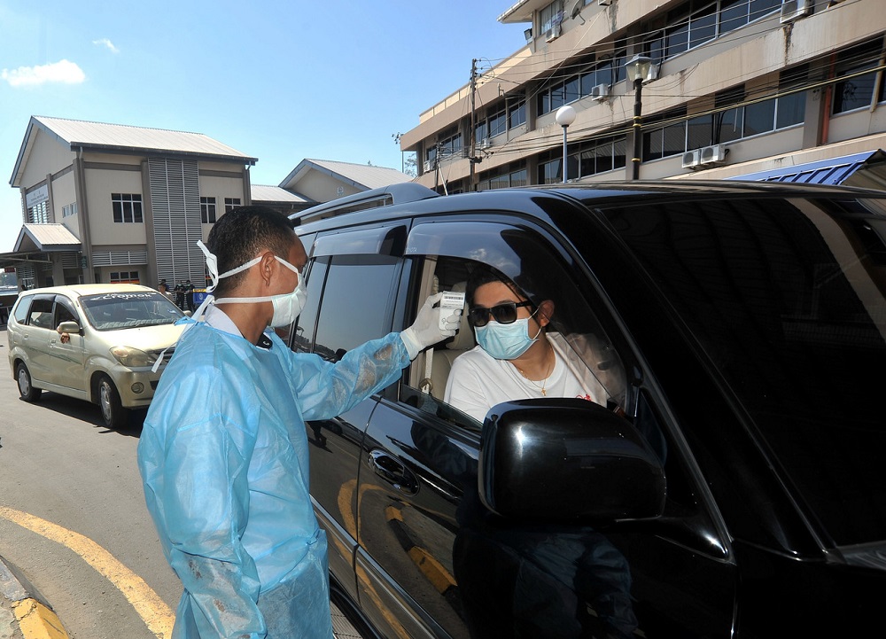 nA health worker checks the temperature of a motorist in Labuan during the movement control order March 23, 2020. u00e2u20acu201d Bernama pic