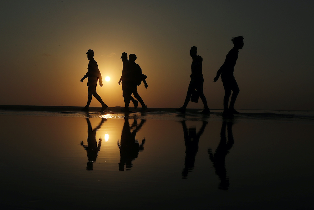 Palestinians walk along a beach during sunset amid concerns about the spread of the coronavirus disease, in Gaza City April 17, 2020. — Reuters pic