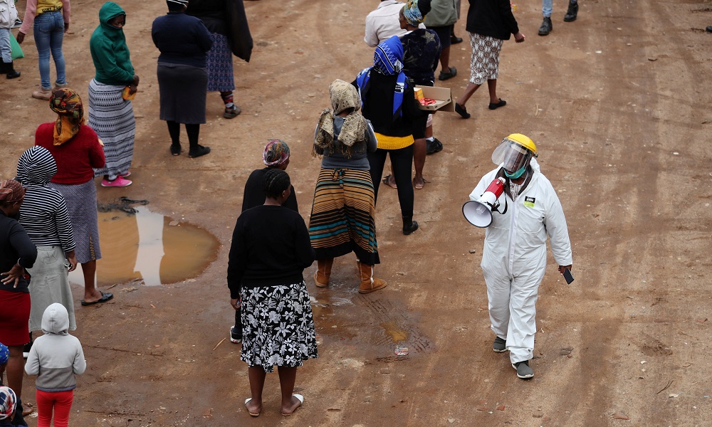 A man in protective clothing speaks trough a loud hailer as he addresses locals queueing ahead of food distribution amid the spread of the coronavirus disease, in Alexandra township, South Africa April 28, 2020. u00e2u20acu2022 Reuters pic
