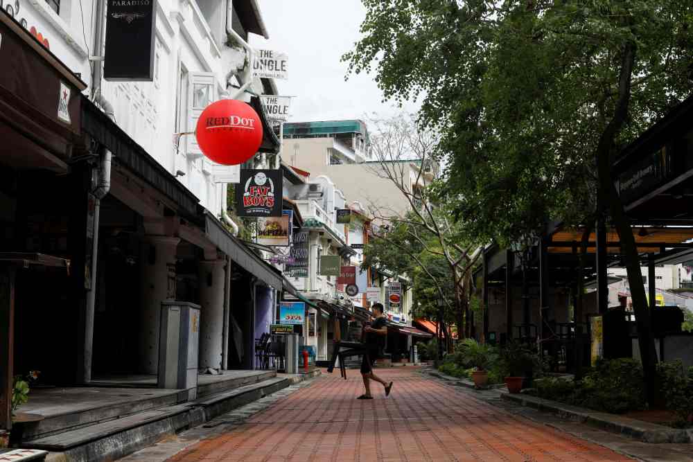 A person carries chairs on the first day of u00e2u20acu02dccircuit breakeru00e2u20acu2122 measures to curb the outbreak of coronavirus at Boat Quay in The Central business district area in Singapore, April 7, 2020. u00e2u20acu2022 Reuters pic