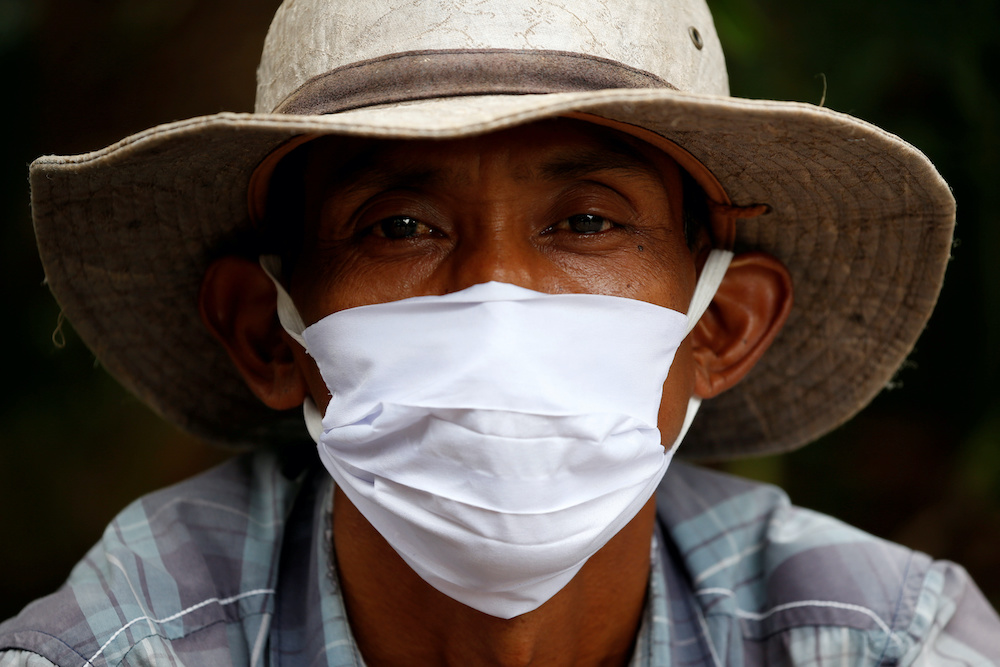 A street vendor wearing a protective mask sits as he waits for customers, as the government imposed large-scale restrictions to prevent the spread of coronavirus disease, during the holy fasting month of Ramadan, in Jakarta, Indonesia, April 25, 2020. u00e2u20acu2022