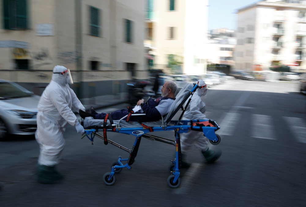 Medical staff in full protective gear carry a patient on a stretcher down a street in Naples, as the spread of coronavirus disease (Covid-19) continues, Italy, April 2, 2020.u00e2u20acu201d Reuters picnn