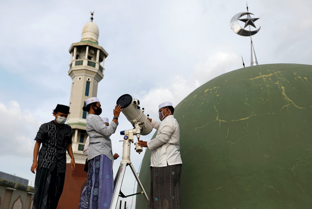 Boarding school students wearing protective masks use a telescope to view the moon on the roof of Al Musariin mosque to mark the first day of Ramadan, as the spread of the coronavirus disease continues, in Jakarta, Indonesia, April 23, 2020. u00e2u20acu201d Reuters p