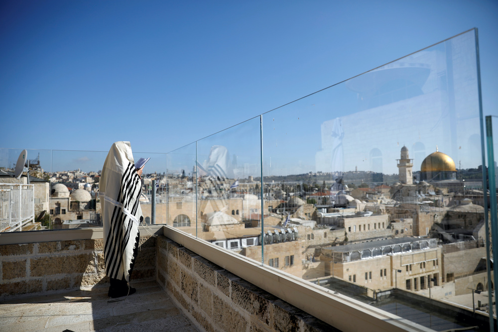 A Jewish worshipper prays on a balcony overlooking the Western Wall as a down-sized priestly blessing, a traditional prayer which usually attracts thousands of worshippers on the holiday of Passover takes place, amid the coronavirus disease (Covid-19) out