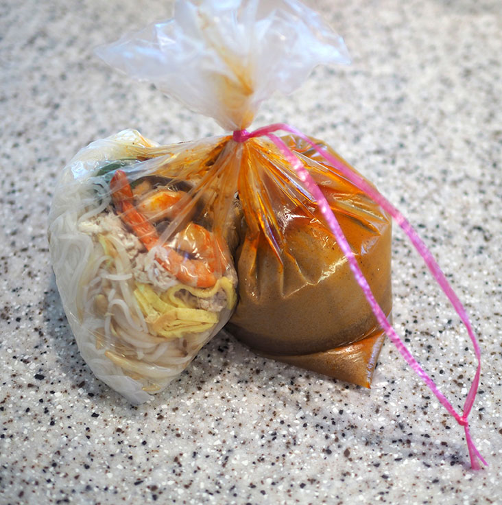 The takeaway laksa has its noodles and broth separated for delivery