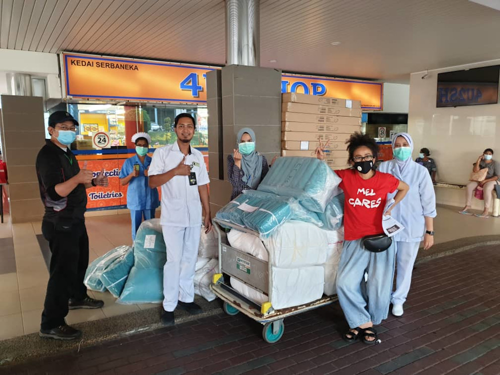 Fashion designer Melinda Looi (in red) handing the PPE gowns to Kuala Lumpur Hospital. u00e2u20acu201d Picture by Melinda Looi