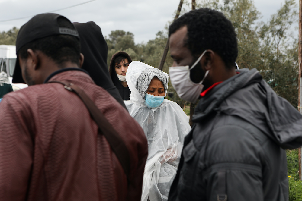 Migrants wearing protective face masks make their way in a makeshift camp for refugees and migrants next to the Moria camp, during a nationwide lockdown to contain the spread of the coronavirus disease (Covid-19), on the island of Lesbos, Greece April 02,
