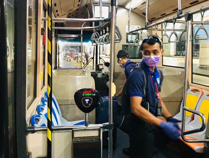 Helpful frontliners help returning Malaysians with their luggage into buses.