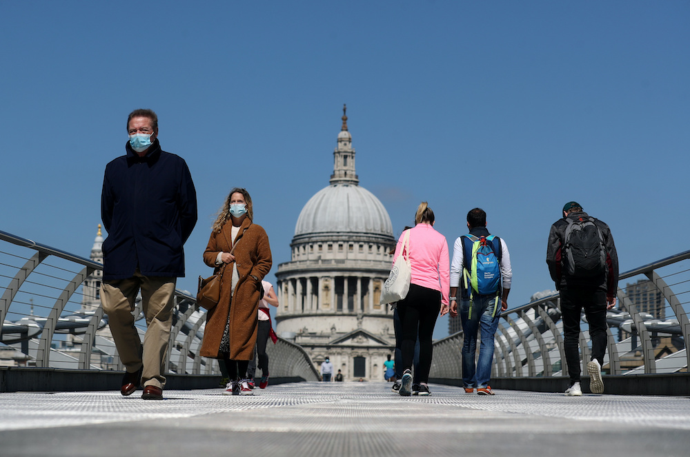 People wearing face masks cross Millennium Bridge, as the spread of the coronavirus disease continues, in London, Britain, April 25, 2020. u00e2u20acu2022 Reuters picnn
