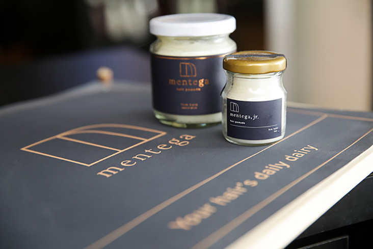 Tan’s hair pomade comes in a standard six-ounce jar (Mentega Classic Firm Hold) and a travel-sized one-ounce jar (Mentega Classic Jr.)