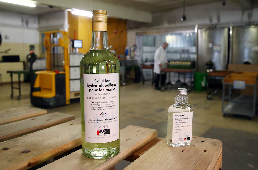 Bottles of pear and mint alcohol is pictured in a labeller at Swiss distiller Morand as the company started using their fruit alcohol to produce hand sanitiser to meet local demand during the coronavirus disease (Covid-19) outbreak in Martigny, Switzerlan