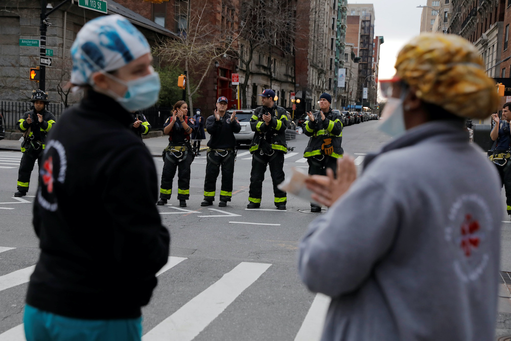 Members of the Ladder 22 and Engine 76 fire crews of the New York Fire Department clap for health and medical workers from the Mount Sinai Morningside hospital during the coronavirus disease (Covid-19) outbreak in Manhattan, New York City, US April 2, 202