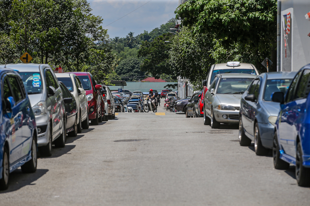 Cars parked on the streets in the morning on an otherwise empty street as residents at PPR Kerinchi head to work. — Picture by Hari Anggara