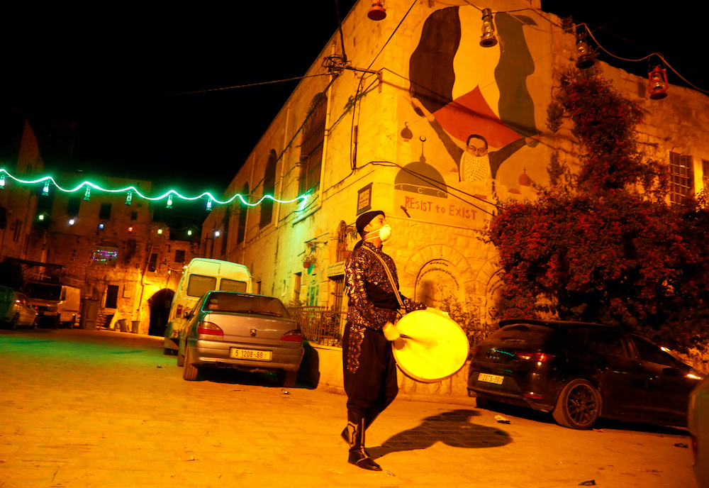 A Palestinian Musharati wearing a mask beats a drum to wake Muslims up to have the predawn in Nablus, in the Israeli-occupied West Bank April 28, 2020. — Reuters pic