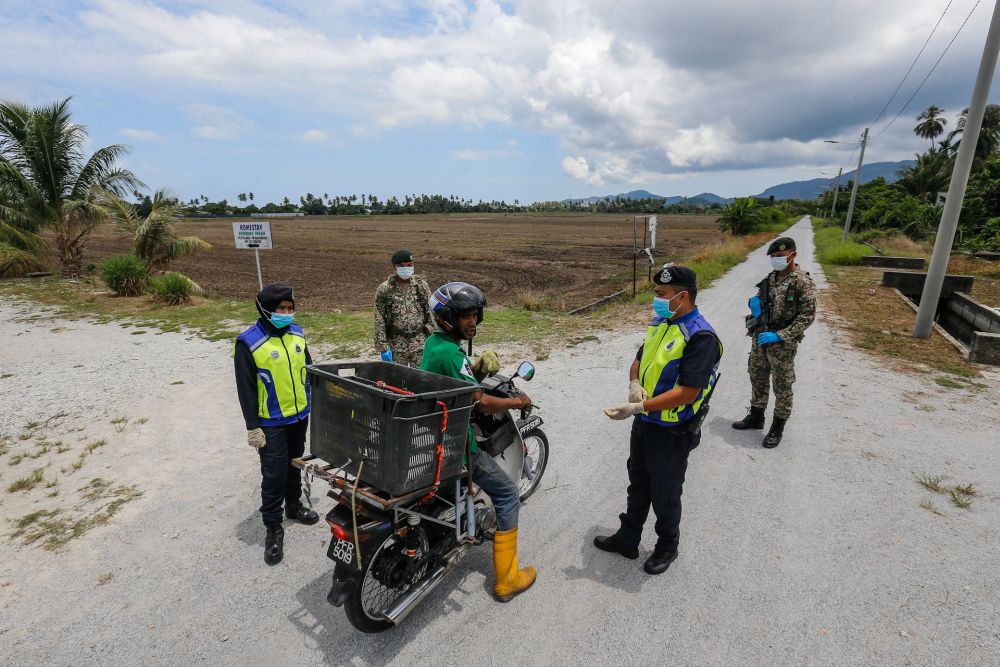Police and Armed Forces personnel conduct checks on a motorist in Kampung Pulau Betong in Balik Pulau April 8, 2020. u00e2u20acu201d Picture by Sayuti Zainudin