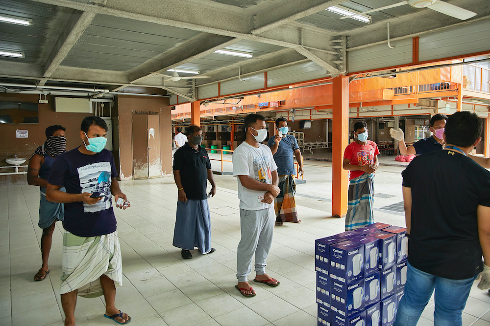 People wearing face masks keep a safe distance from others during a briefing in Punggol dormitory, as the outbreak of the coronavirus disease continues, in Singapore April 7, 2020. u00e2u20acu201d Reuters picnn
