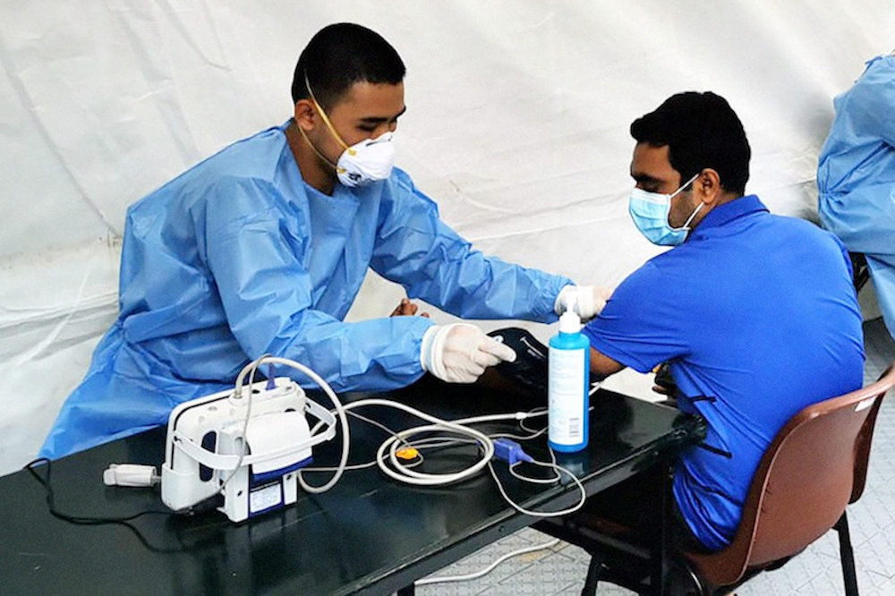 An Academy of Medicine staff attends to a migrant worker at a dormitory in Singapore, after nearly 20,000 workers were quarantined, amid the coronavirus disease (Covid-19) outbreak, April 7, 2020. u00e2u20acu201d Reuters pic